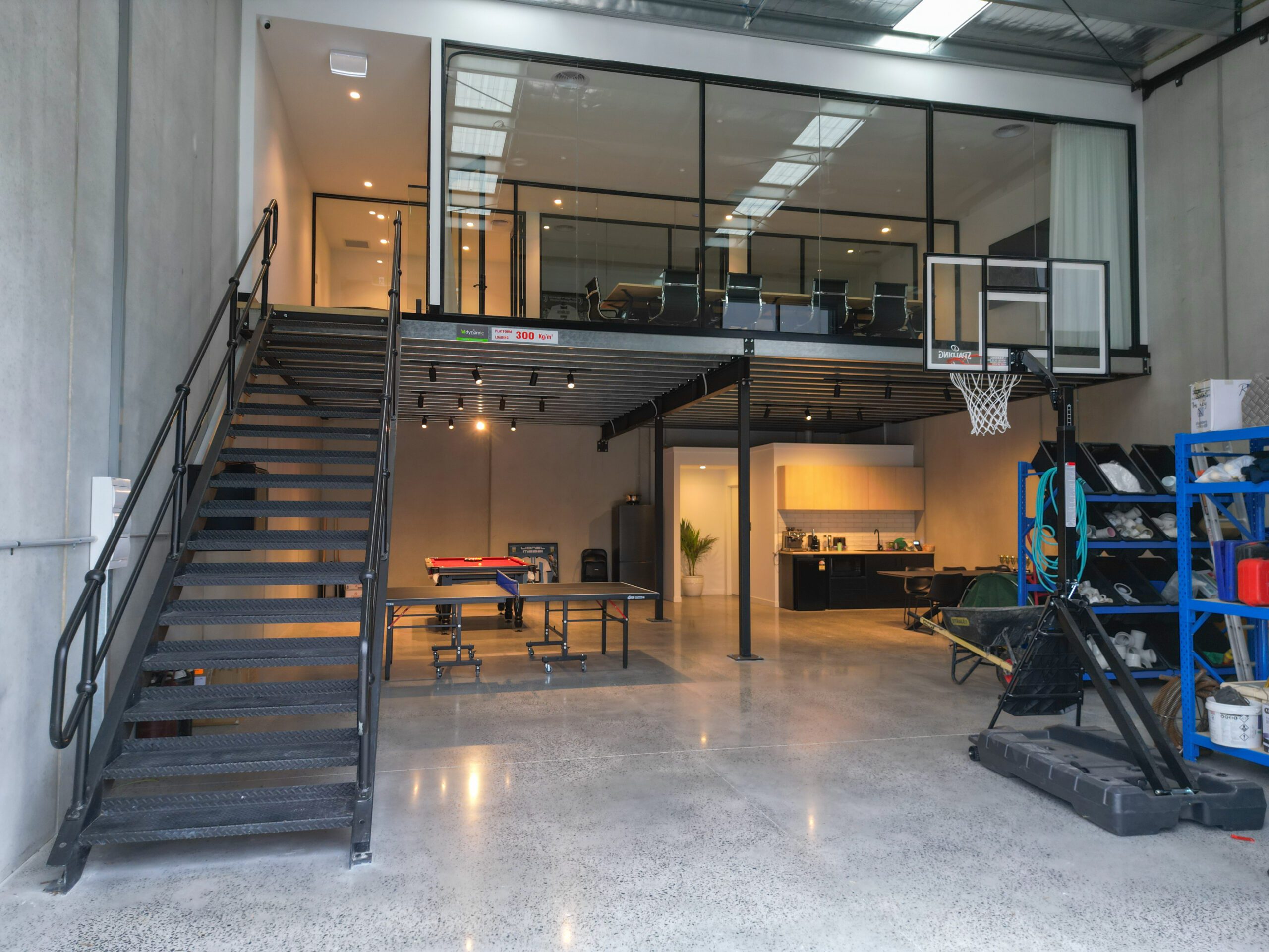 Spacious industrial warehouse with modern mezzanine floor, including office space and recreational area, showcasing efficient design.