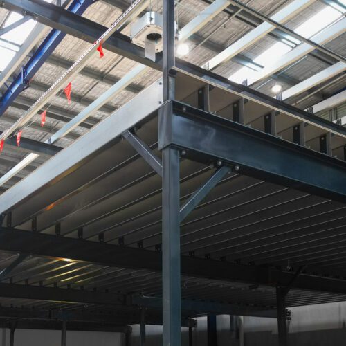 Structural mezzanine floor showing steel staircase and safety balustrade installation.